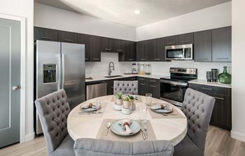 A modern kitchen with a dining table set for two.